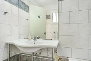 a white bathroom with a sink and a mirror at Mezoneta 1 in Nydri