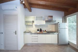 Una cocina con gabinetes blancos y un refrigerador blanco. en AkiHouse - rooms and apartments on Garda Lake, en Lonato