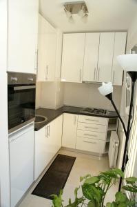 a kitchen with white cabinets and a black counter top at Apartment Max in Banja Luka