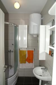 a bathroom with a sink and a shower with towels at Apartment Max in Banja Luka