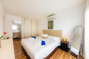 a bedroom with a white bed with a teddy bear on it at Apartamento Vista Mar in Alcudia +19 photos