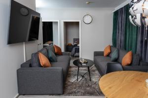 een woonkamer met twee banken en een tv bij Apartment Haapala A11 in Rovaniemi +22 foto's