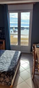 une chambre avec un lit et une vue sur l'océan dans l'établissement Appartement La Plage Plouha, à Plouha
