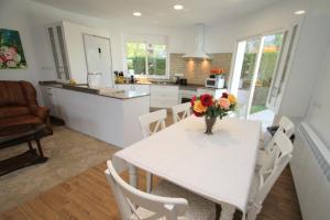 una cocina con una mesa con un jarrón de flores. en ARENDA Villa Camila Pino Alto, en Miami Platja