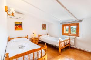 a bedroom with two beds and a window at Villa Poley in Pollença +16 photos