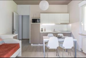 una cucina con mobili bianchi, tavolo e sedie di Trilocale colline di Bardolino a Bardolino Altre 8 foto