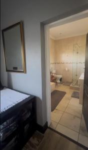 a bathroom with a tub and a mirror on the wall at Madeley House Unit 2 near Oliver Tambo Airport in Boksburg