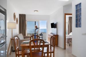 Una sala de estar con una mesa y sillas y un sofá. en Callao Beach 1, en Arrieta