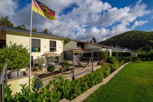 a flag flying in front of a house with a playground at Ferienwohnung Zur Quelle in Plettenberg