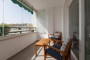 balkon z 2 krzesłami, stołem i oknem w obiekcie Apartamento en Sotomar La Carihuela w mieście Torremolinos
