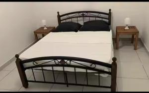 a bedroom with a black bed with two tables at Kaz'Eliz in Le Tampon