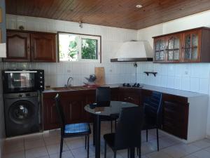 a kitchen with a table and a sink and a dishwasher at Kaz'Eliz in Le Tampon