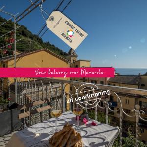 a table with glasses of wine on a balcony at Liersena Sea View Mini Villa with AC in Manarola