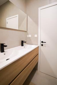 ブリュッセルにあるAppartment Wayez 3の白い洗面台と鏡のあるバスルーム