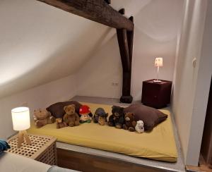 un montón de animales de peluche sentados en una cama en Ferienhaus im Pochwerksgrund in Suhl Goldlauter im Thüringer Wald, en Suhl