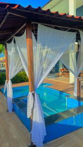 ベレンにあるAlphaville Belémの白いカーテンが付いたスイミングプール