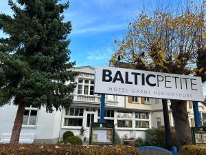 a hotel sign in front of a building at Hotel Garni BALTICpetite in Heringsdorf