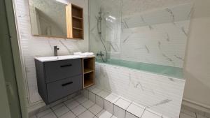 een witte badkamer met een wastafel en een douche bij Reflet de Loire in Nevers +4 foto's