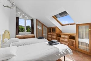 ein Schlafzimmer mit zwei Betten und einem Fenster in der Unterkunft Villa de lujo en Cantabria in Puente Arce