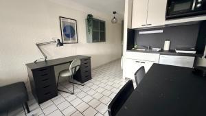 een keuken met een bureau en een tafel en stoelen bij Reflet de Loire in Nevers