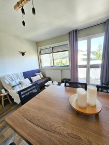 a living room with a table and a couch at Appartement avec chambre Gourette in Gourette