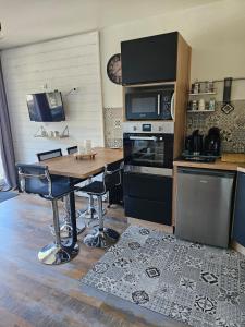 a kitchen with a table with a microwave and a stove at Station de ski Gourette, Appartement avec chambre in Gourette +14 photos