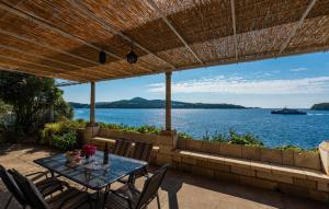 a table and chairs on a patio with a view of the water at Beach house Lozica by Villas Guide in Dubrovnik