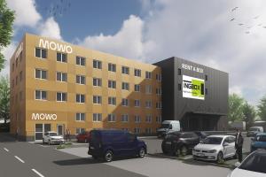 een groot geel gebouw met auto's geparkeerd op een parkeerplaats bij MOWO Limes in Denkendorf