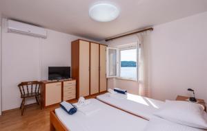 a bedroom with two beds and a television and a window at Beach house Lozica by Villas Guide in Dubrovnik