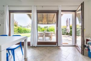 a dining room with a table and a sliding glass door at Villa Bouganville Cala Sinzias in Cala Sinzias +15 photos