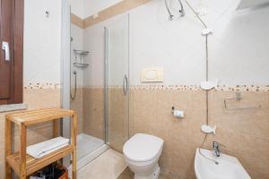 a bathroom with a shower and a toilet and a sink at Villa Bouganville Cala Sinzias in Cala Sinzias