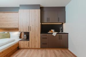 a bedroom with a bed and a small kitchen at MOWO Limes in Denkendorf