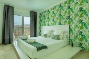 ein Schlafzimmer mit einem weißen Bett mit einem großen Fenster in der Unterkunft Villa Happy Dreamer in Puerto Rico de Gran Canaria + 13 Fotos