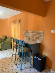 a kitchen with a table and chairs in a room at Sumanguru Airport Studios in Busumbala
