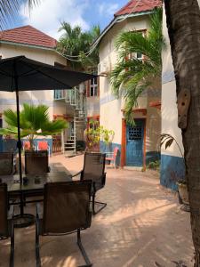 a patio with a table and an umbrella at Sumanguru Airport Studios in Busumbala