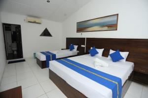 a hotel room with two beds with blue pillows at Hotel sunflower in Dambulla +73 photos