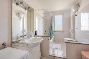 a white bathroom with a sink and a toilet at Tra Mare e Campagna - Cortile privato e relax in Palmas Arborea