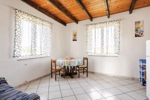 a dining room with a table and two windows at Tra Mare e Campagna - Cortile privato e relax in Palmas Arborea +7 photos