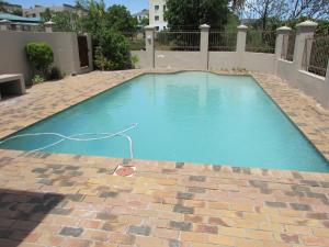 a swimming pool with a hose on a brick patio at Serengeti Self Catering Units in Bellville