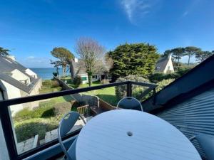ein Tisch und Stühle auf einem Balkon mit Blick auf das Meer in der Unterkunft Appartement bord de mer à Saint-Pierre-Quiberon avec balcon et garage - FR-1-478-181 in Saint-Pierre-Quiberon