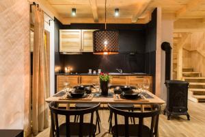 a kitchen with a table with chairs and a stove at Domek Babcynówka in Zakopane +12 photos