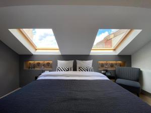 a bedroom with a large bed with two skylights at Namur Suites in Mellet