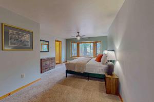 a bedroom with a bed and a dresser and a window at Camp Farrell House in Manitowish Waters