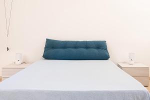 a blue pillow sitting on top of a bed at Dimora Bianca in San Cesario di Lecce