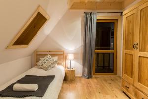 a small bedroom with a bed and a window at Domek Babcynówka in Zakopane