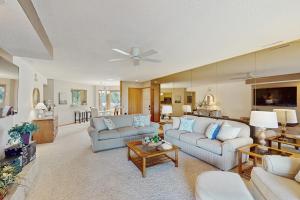 a living room with two couches and a table at Whispering Breeze Condo in Laguna Beach