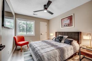 a bedroom with a bed and a red chair at Modern Updated Elite 3BR Beach Home! Close to Golf Course & Beach! in Myrtle Beach