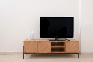 a flat screen tv sitting on top of a wooden entertainment center at Dimora Bianca in San Cesario di Lecce