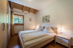 a bedroom with a large bed and a window at Tischlerhof - Typ A mit Terrasse in Tirolo