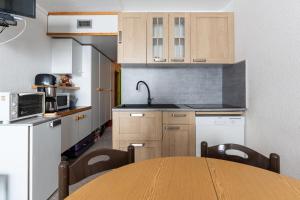 a kitchen with a table and a sink and cabinets at Studio 5 P Les Arcs 2000 Pieds Des in Bourg-Saint-Maurice